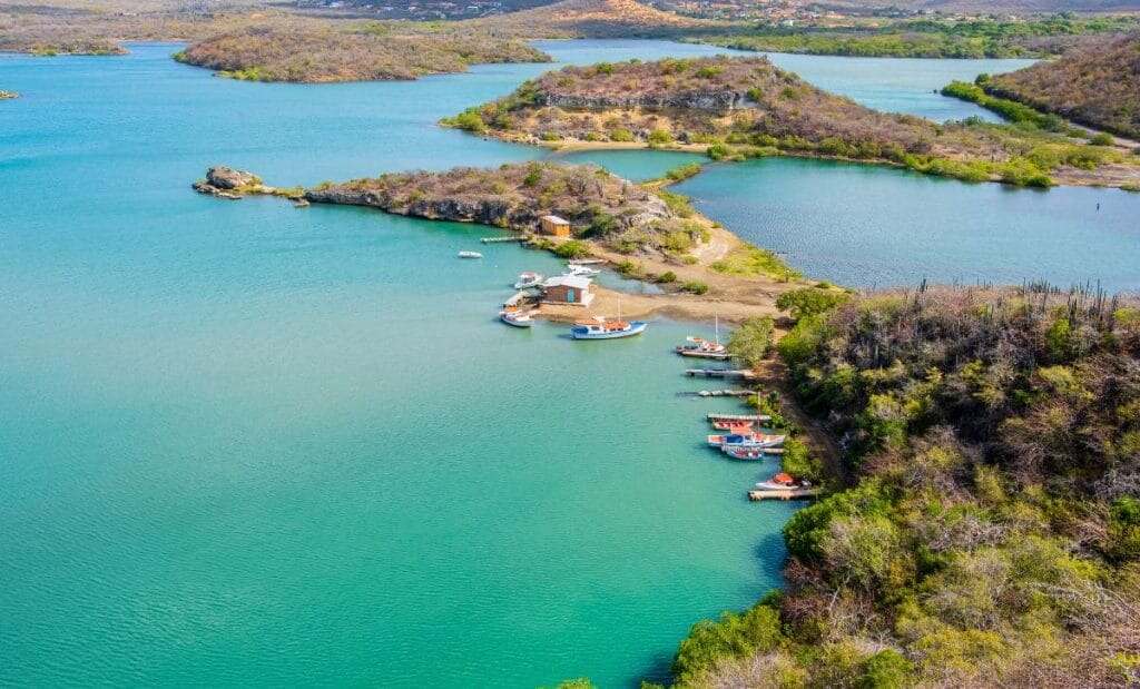 vista aérea de baía em Curaçao com barcos ancorados e natureza ao redor