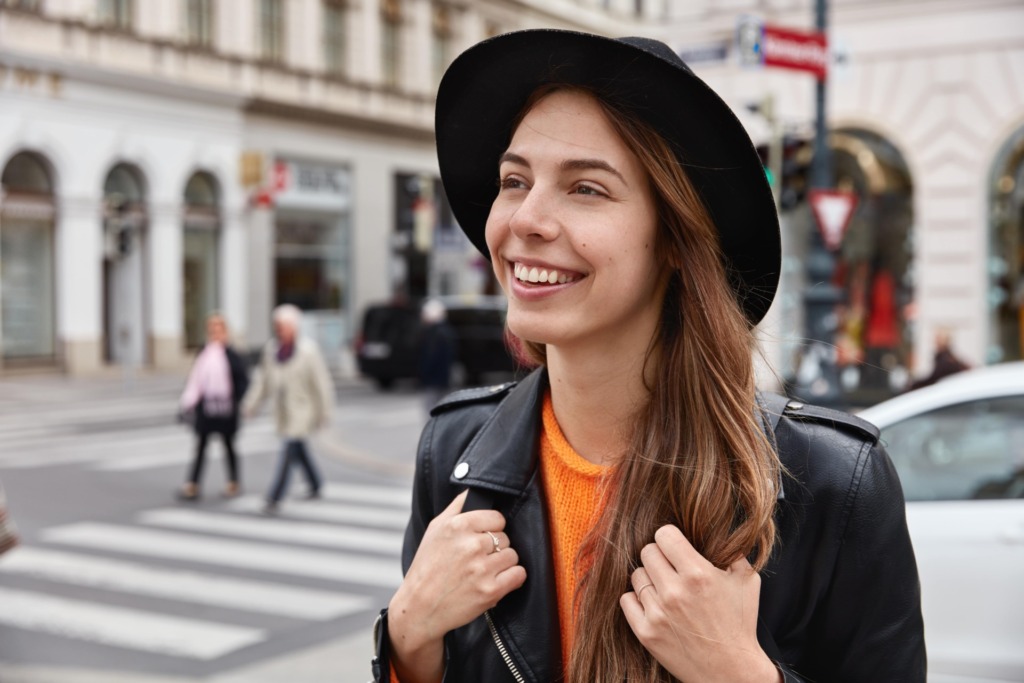 delighted female tourist has glad expression has toothy smile with white teeth excursion city min